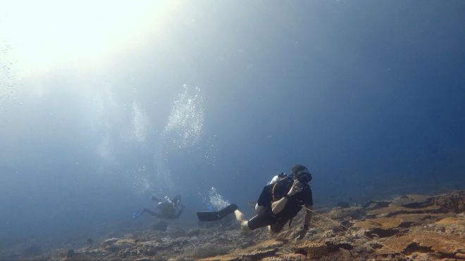 Taucher in starker Strömung mit Riffhaken in Komodo
